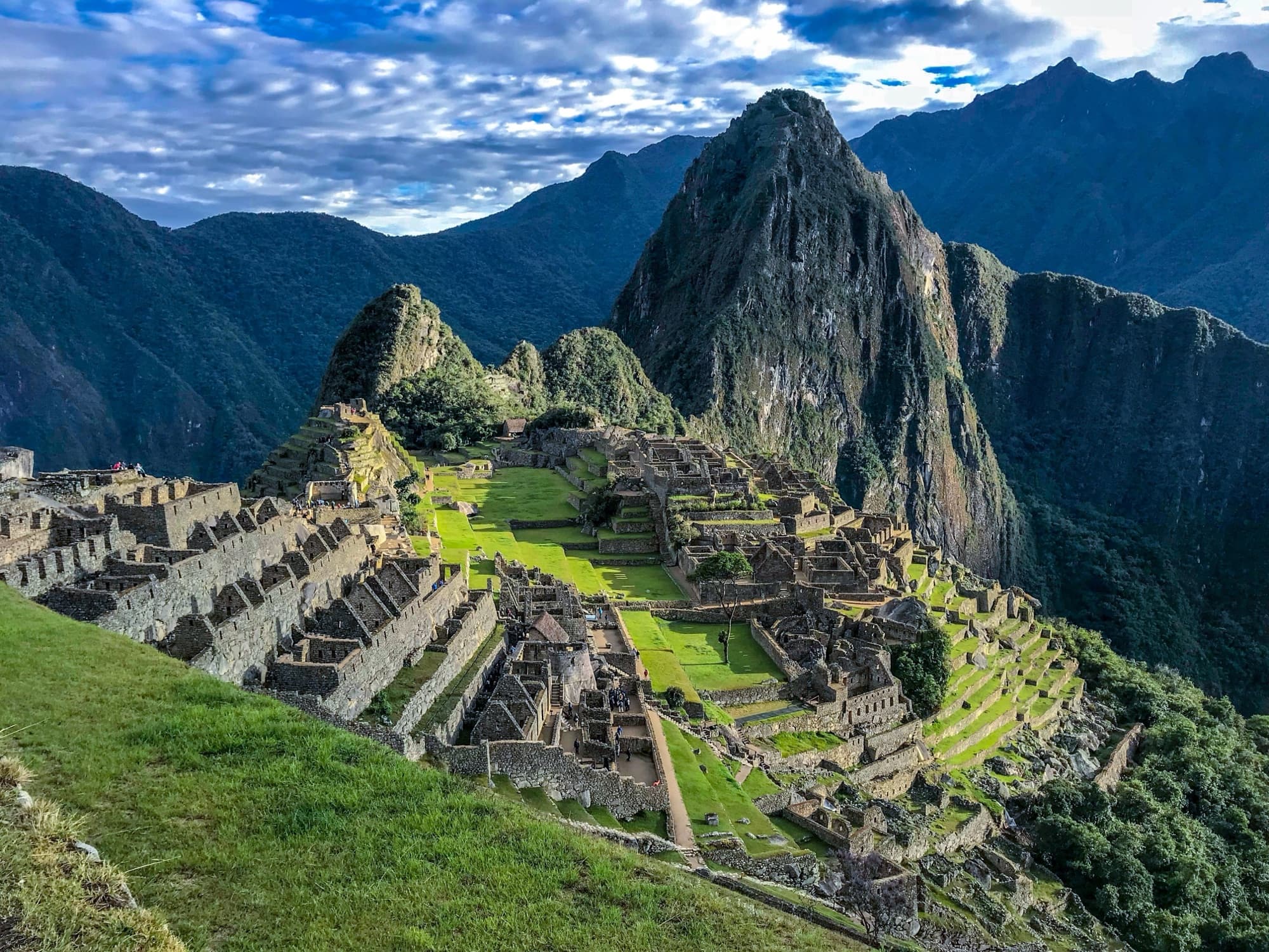 Machu Picchu a la hora dorada, la ciudadela inca en terrazas sobre la ladera verde del valle del Urubamba en Perú.